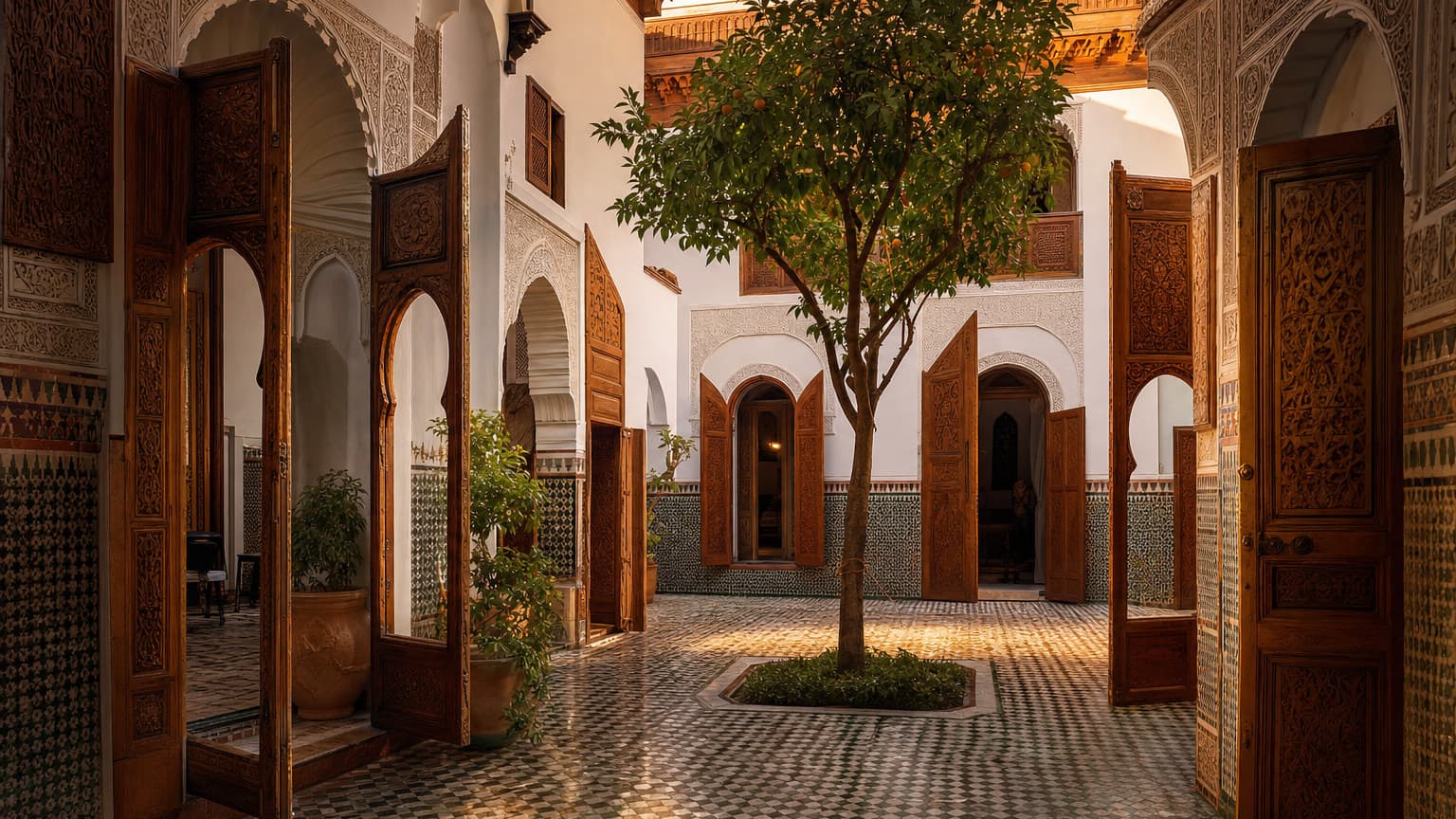 A traditional Moroccan family riad courtyard at golden hour, several carved wooden doors opening onto a shared central courtyard with zellige tile and a citrus tree